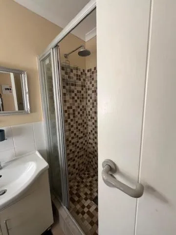 Modern bathroom with tiled shower enclosure and pedestal sink