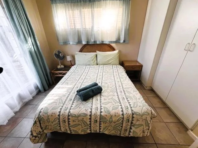 Cozy bedroom with double bed, wooden nightstands, and natural window light