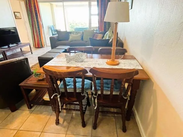 Wooden dining table with chairs in open-plan apartment interior