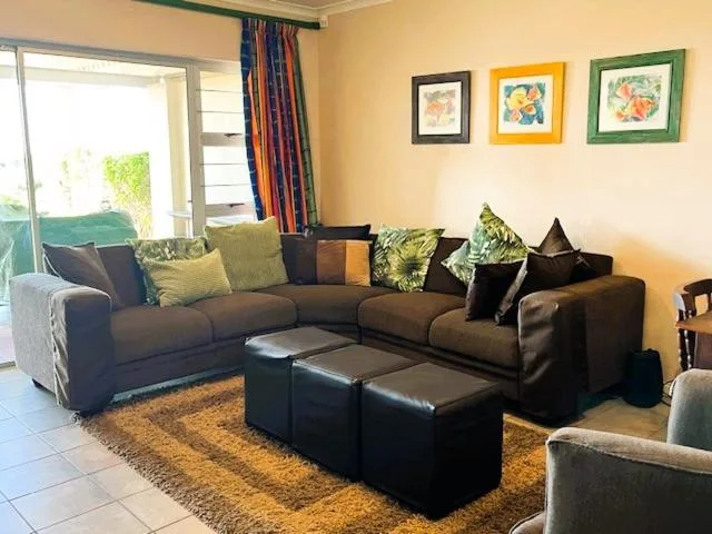 Spacious living room with brown sectional sofa and colorful accent pillows