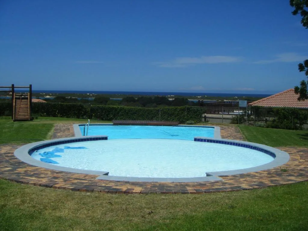 Oval swimming pool with spa and ocean view overlooking Plettenberg Bay