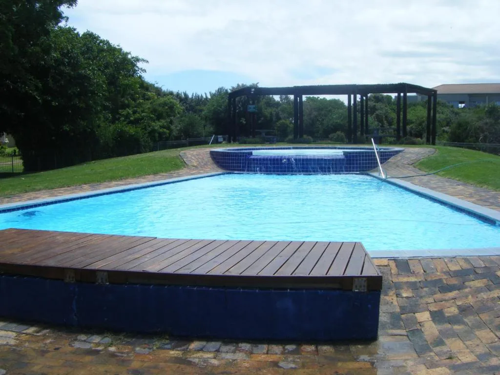 Sparkling blue rectangular swimming pool with wooden decking and black pergola shelter