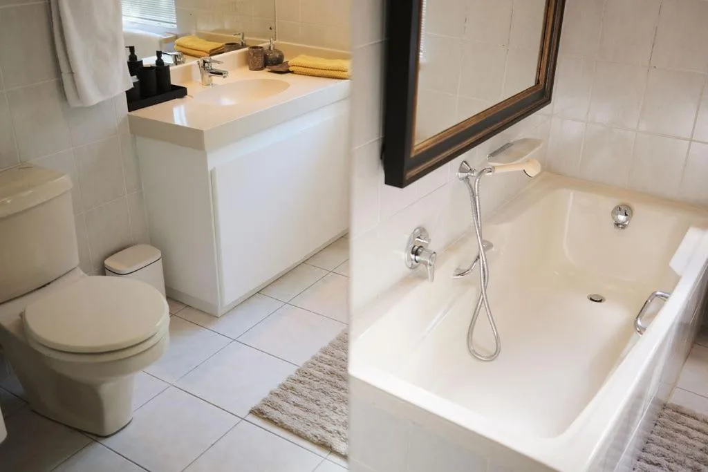Modern bathroom with white vanity, toilet, and walk-in shower with handheld nozzle