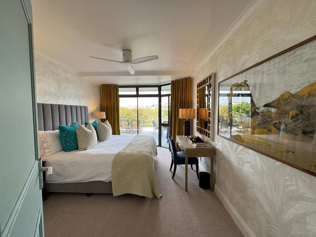 Spacious bedroom with king bed, ocean view doors, and modern furnishings