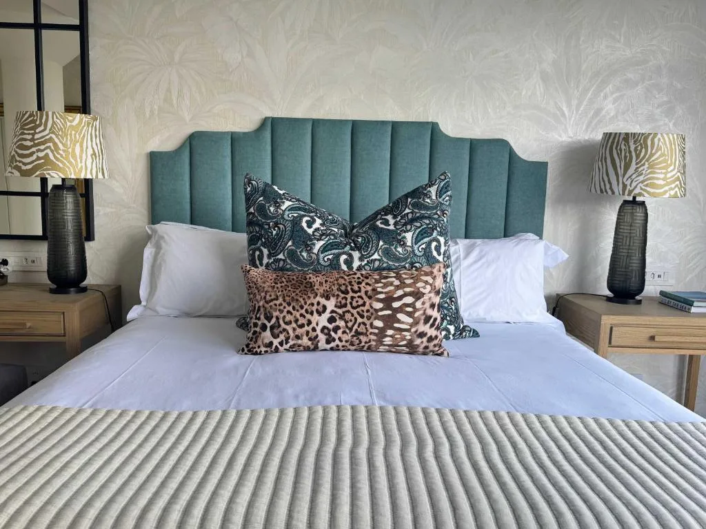 Luxurious bedroom with teal upholstered headboard and decorative pillows