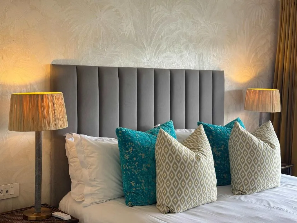 Modern bedroom with upholstered headboard and decorative turquoise pillows