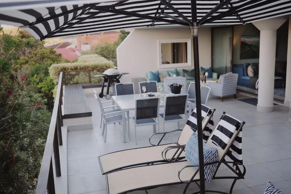 Spacious patio with dining table, lounge chairs, and black pergola shade structure