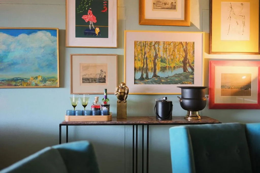 Curated wall gallery and decorative sideboard with artwork and elegant accessories