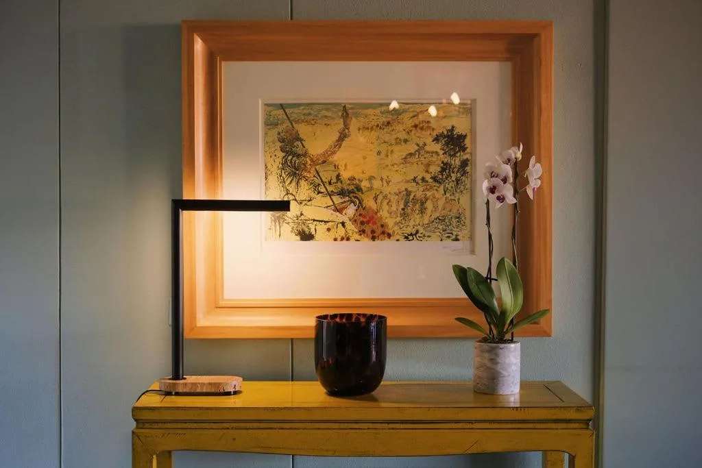 Illuminated wooden wall niche with framed botanical art and orchid plant