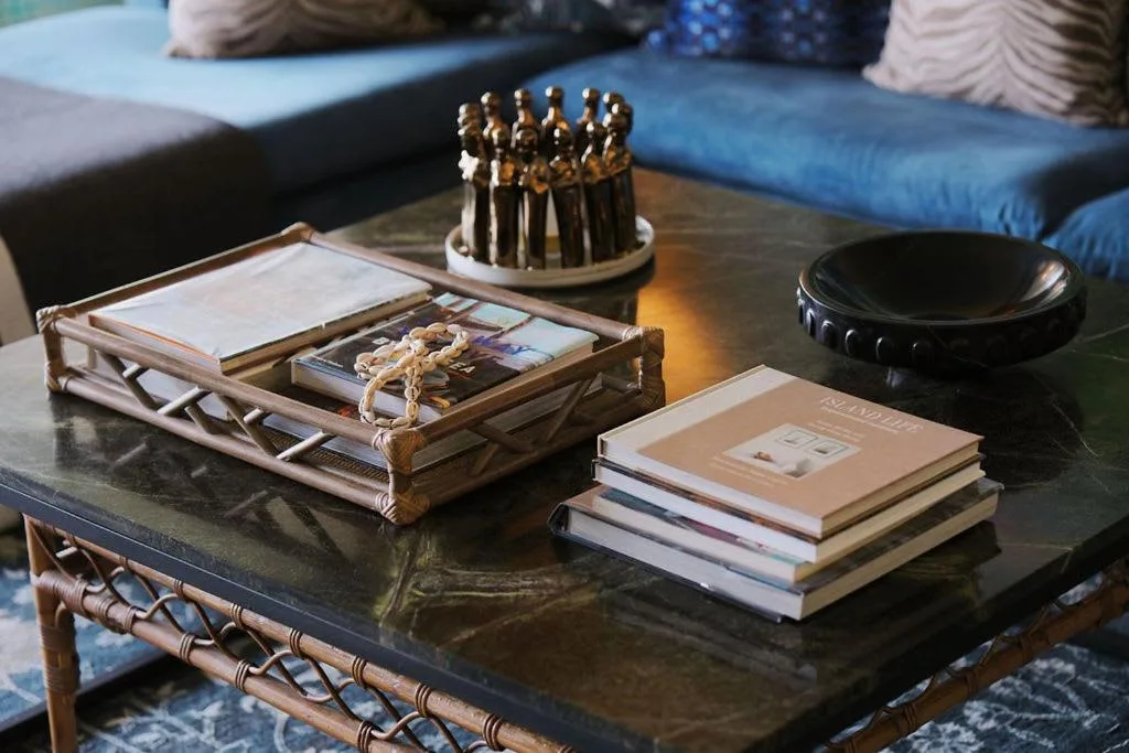 Decorative coffee table with books, sculptures, and ornamental accessories in lounge