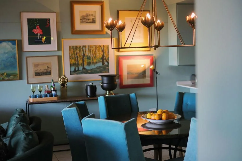 Modern dining area with blue chairs and fruit bowl on table