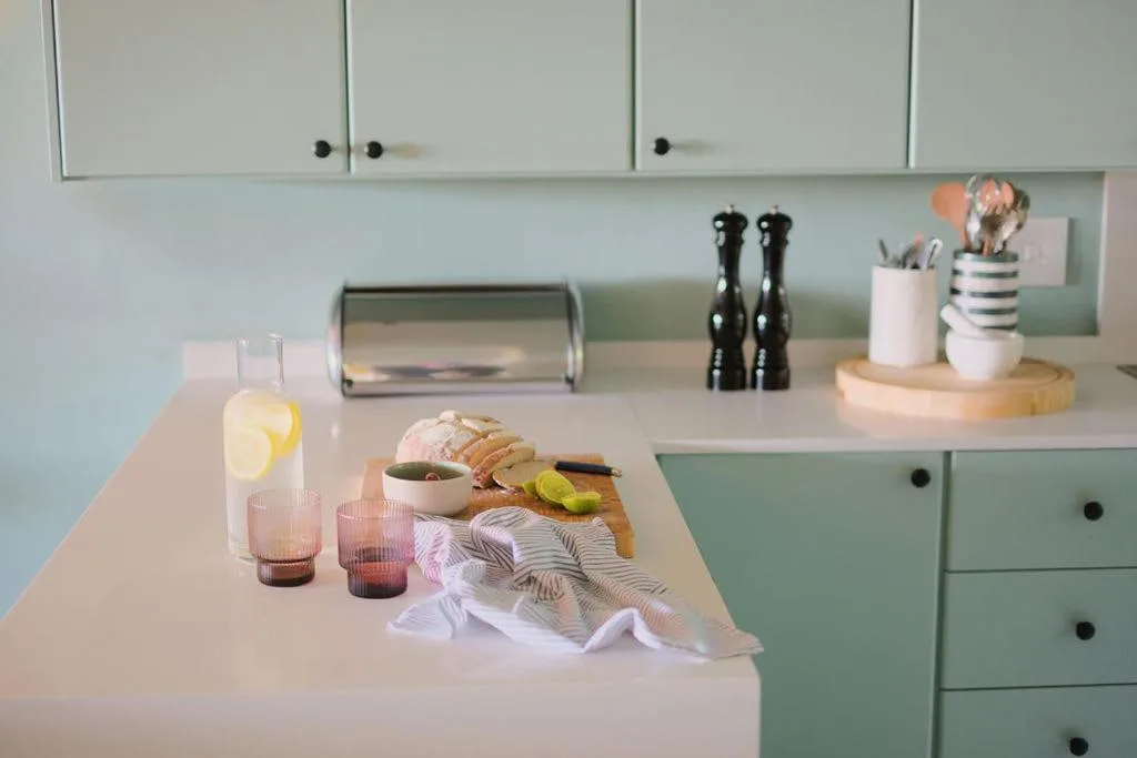 Modern kitchen with pale cabinetry, white countertop, and fresh styling