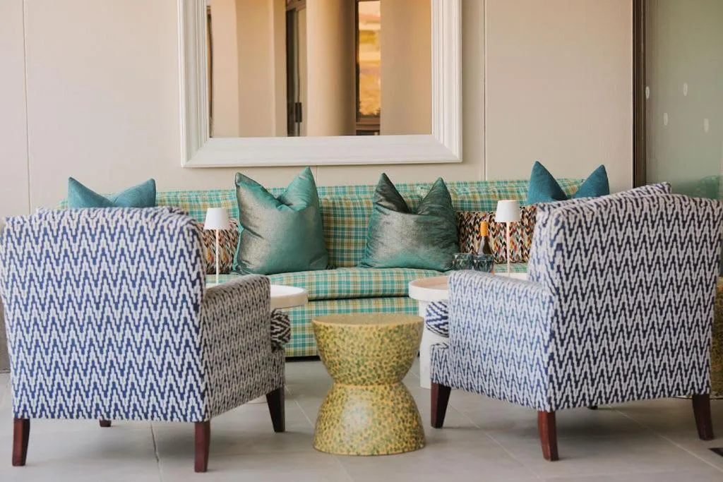 Contemporary lounge with patterned armchairs, teal sofa, and decorative side table