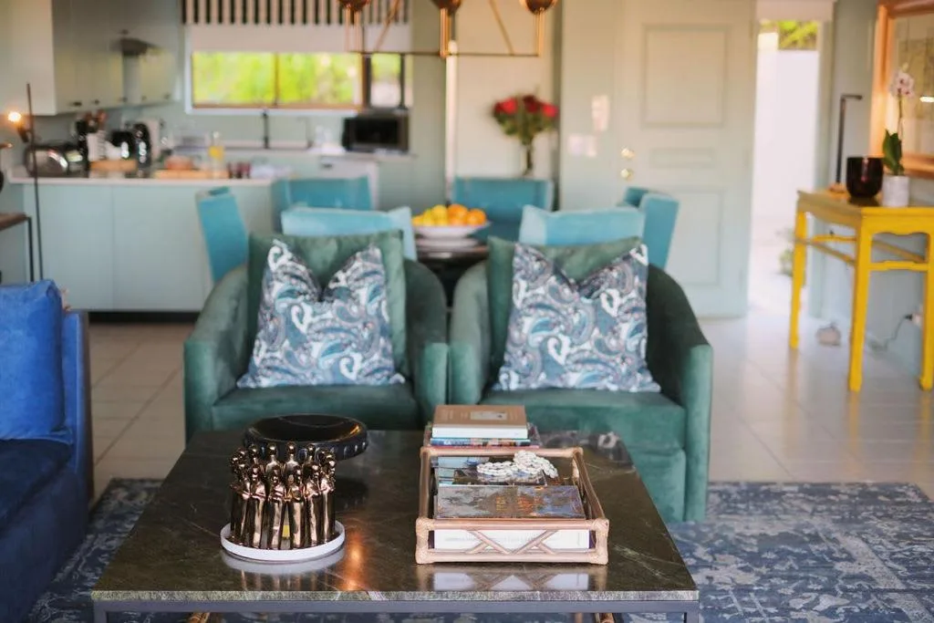 Modern living room with turquoise armchairs and open kitchen view