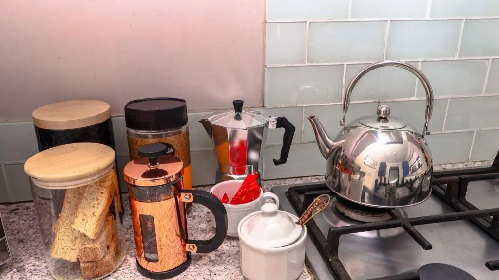 Kitchen countertop with kettle, coffee maker, and storage containers displayed