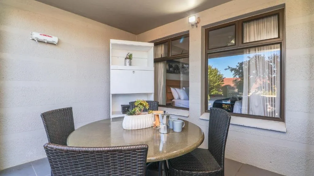 Round dining table with woven chairs overlooking garden views