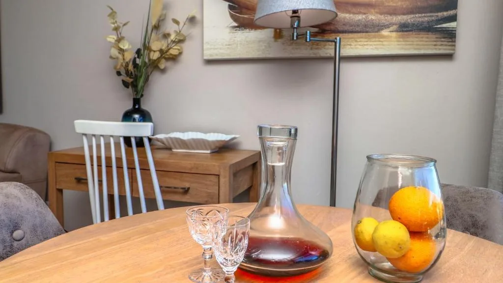 Wooden dining table with fresh citrus fruits and wine decanter displayed