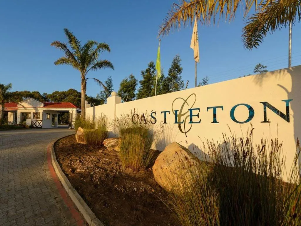 Castleton property entrance sign with landscaping and palm trees