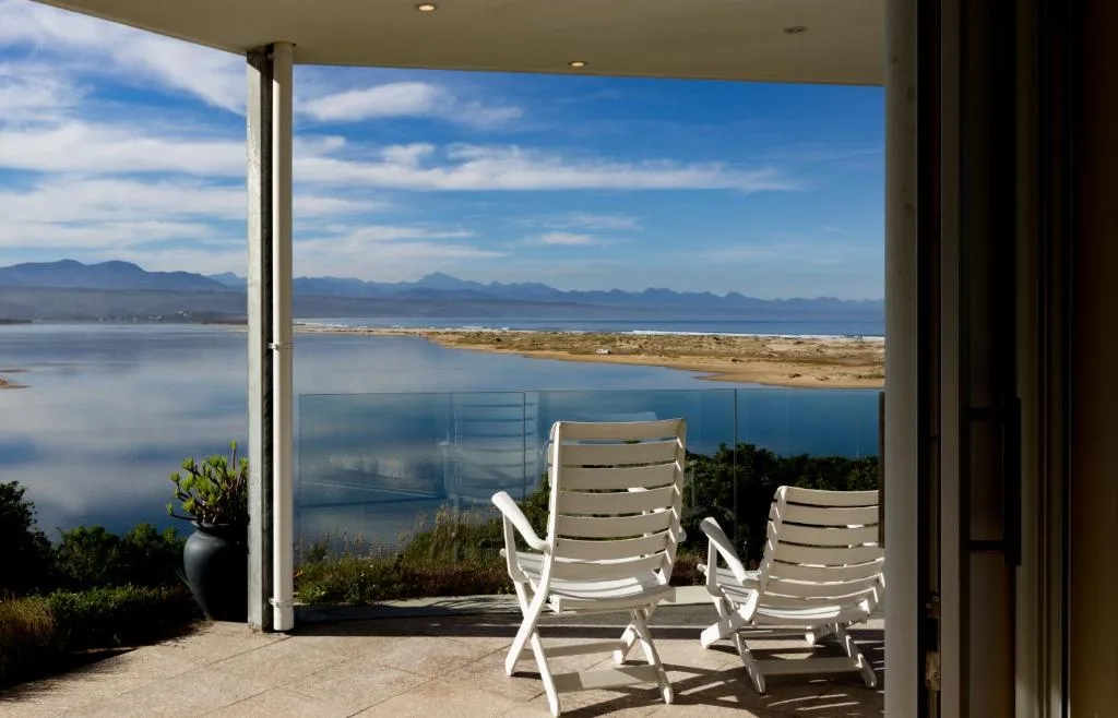 Outdoor deck with lounge chairs overlooking lagoon and mountains