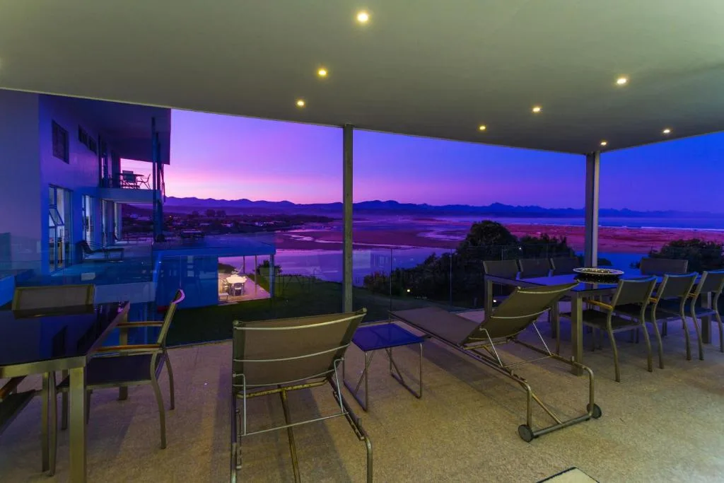 Spacious outdoor deck with comfortable seating overlooking lagoon at dusk