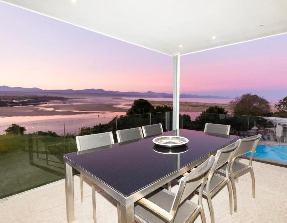 Outdoor dining area with lagoon and mountain views at sunset