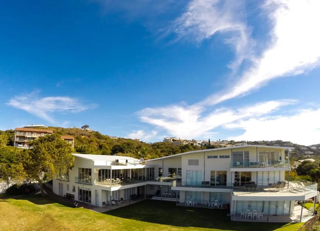 Modern white multi-level villa with expansive gardens overlooking coastal hills