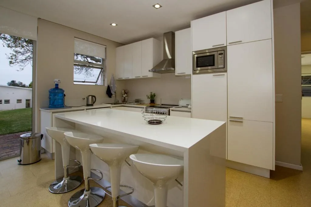 Modern white kitchen with island bench seating and stainless steel appliances