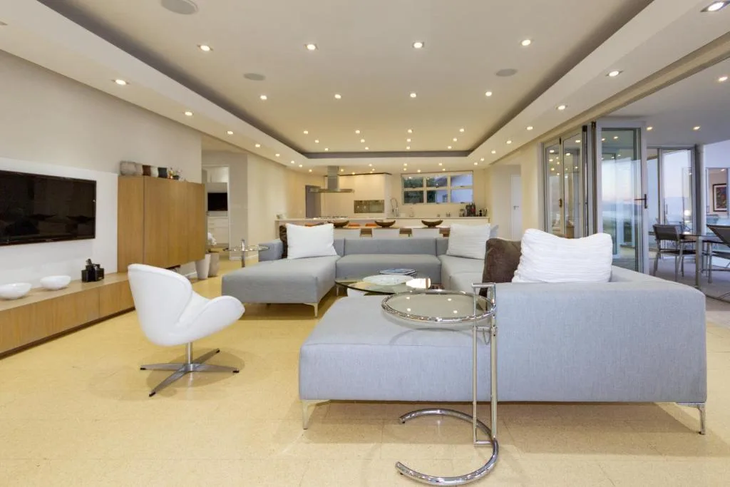 Modern open-plan lounge with gray sectional sofa and kitchen beyond