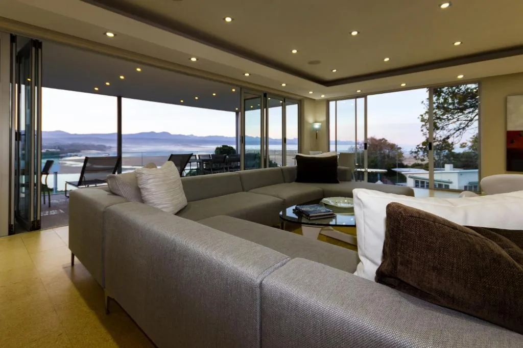 Modern lounge with sectional sofa overlooking scenic lagoon and mountain views