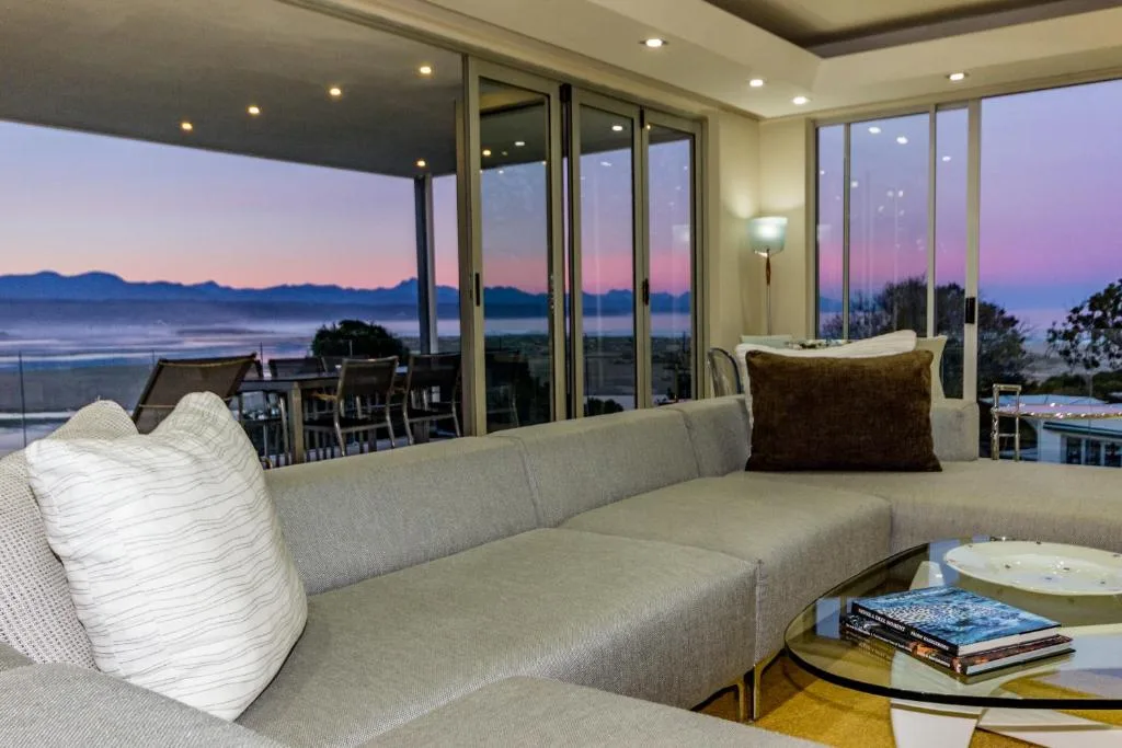Modern lounge with sectional sofa overlooking coastal sunset views