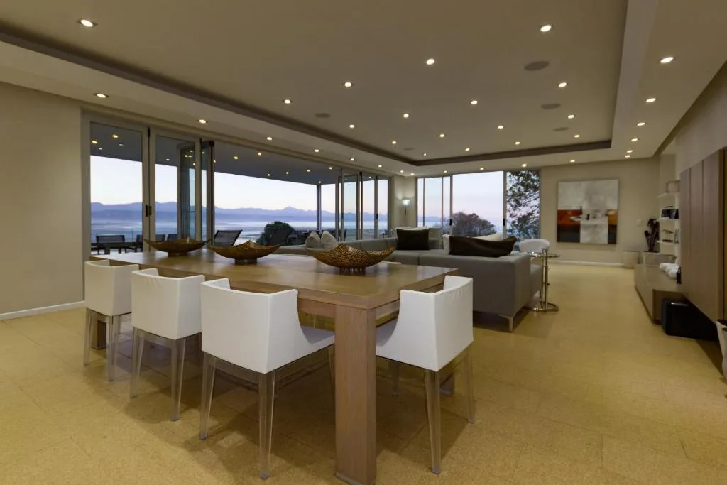 Open-plan lounge and dining area with lagoon views through floor-to-ceiling windows