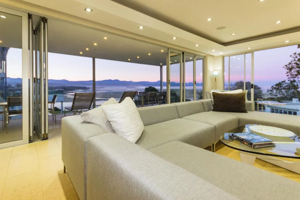 Modern lounge with cream sectional sofa overlooking lagoon at sunset