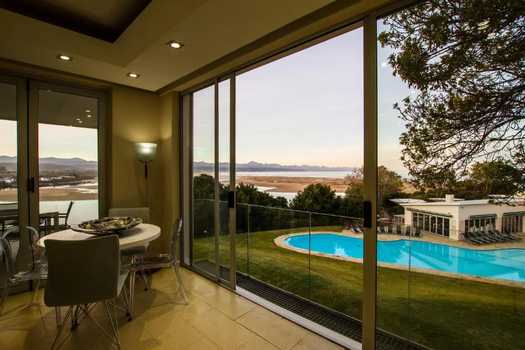 Expansive lagoon and mountain views through floor-to-ceiling windows at sunset