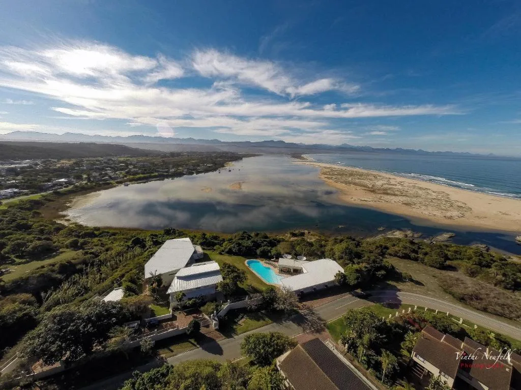 Aerial view of Plett lagoon with mountains, beach, and property below