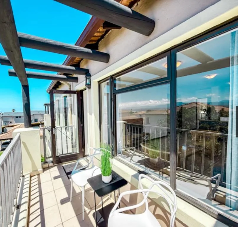 Modern covered deck with table, chairs, and panoramic mountain views