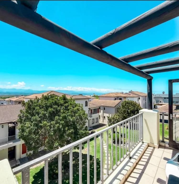 Shaded balcony overlooking neighborhood with mountain views and clear blue sky