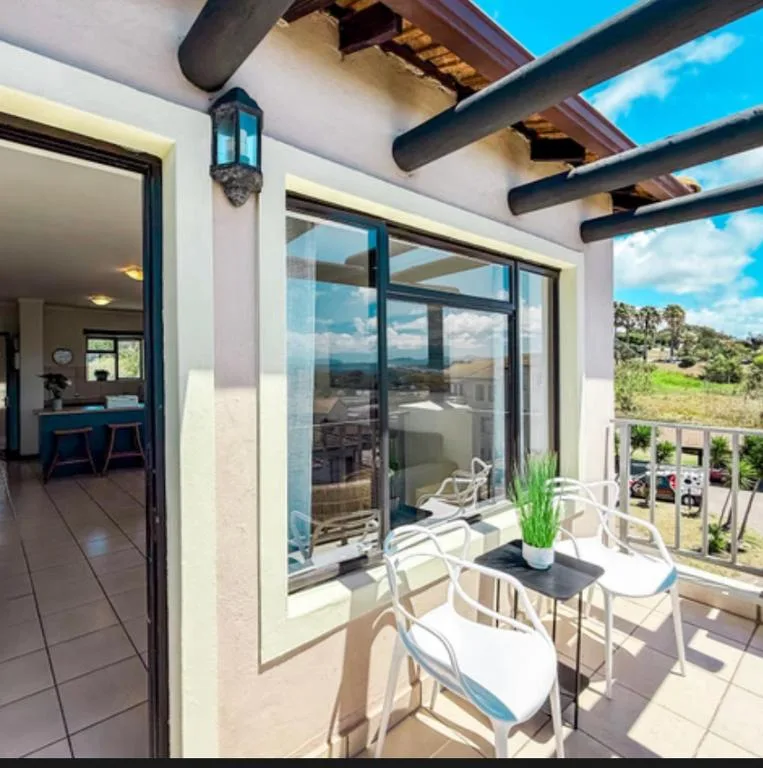 Covered outdoor patio with dining table overlooking mountain landscape