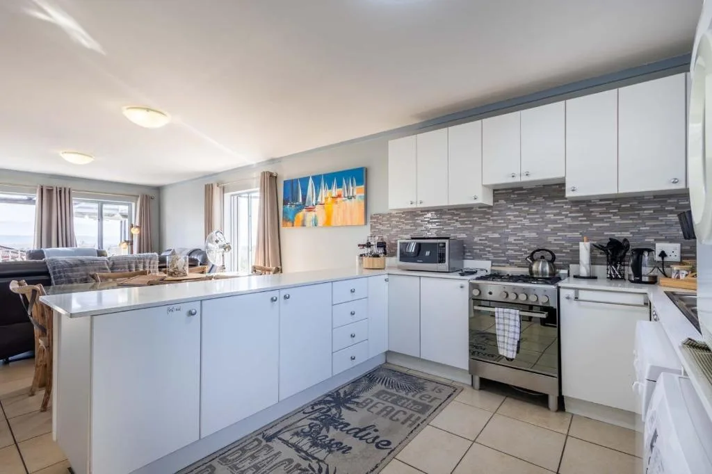Modern white kitchen with stainless steel appliances and tiled backsplash
