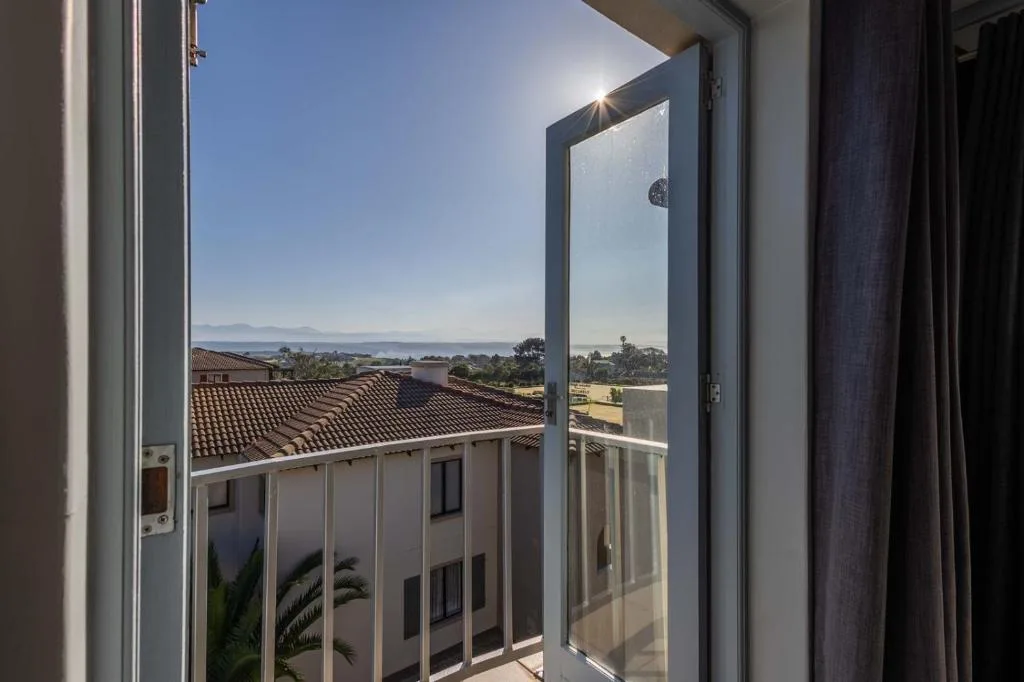 Scenic lagoon and mountain vista through open glass door