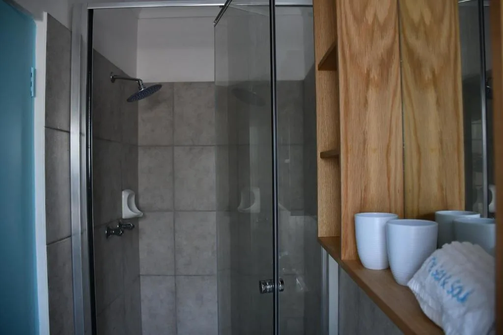 Modern enclosed shower with gray tiles and rainfall showerhead