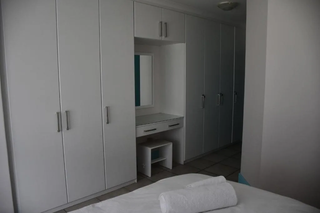 Spacious bedroom with white built-in wardrobes and vanity mirror