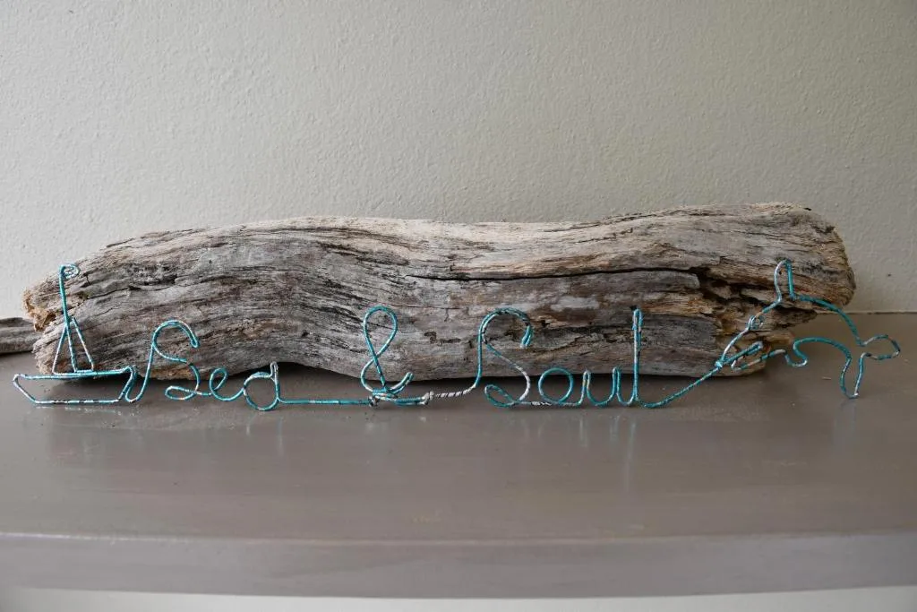 Weathered driftwood with turquoise wire spelling Sea and Soul