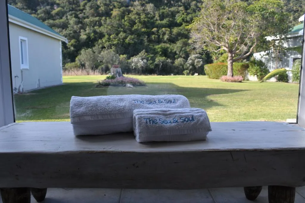 Branded towels displayed on windowsill overlooking expansive manicured gardens