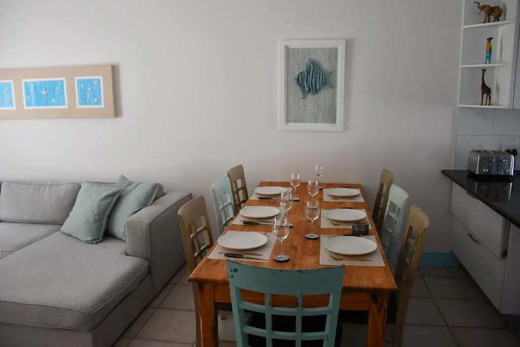 Wooden dining table set for six with place settings and glassware