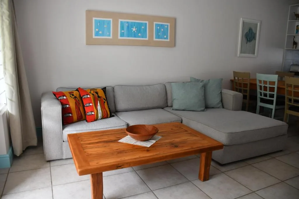 Spacious lounge with grey sectional sofa and wooden coffee table