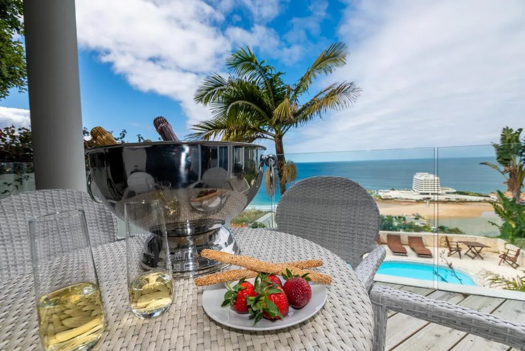 Outdoor table with wine, snacks, and ocean view from elevated deck