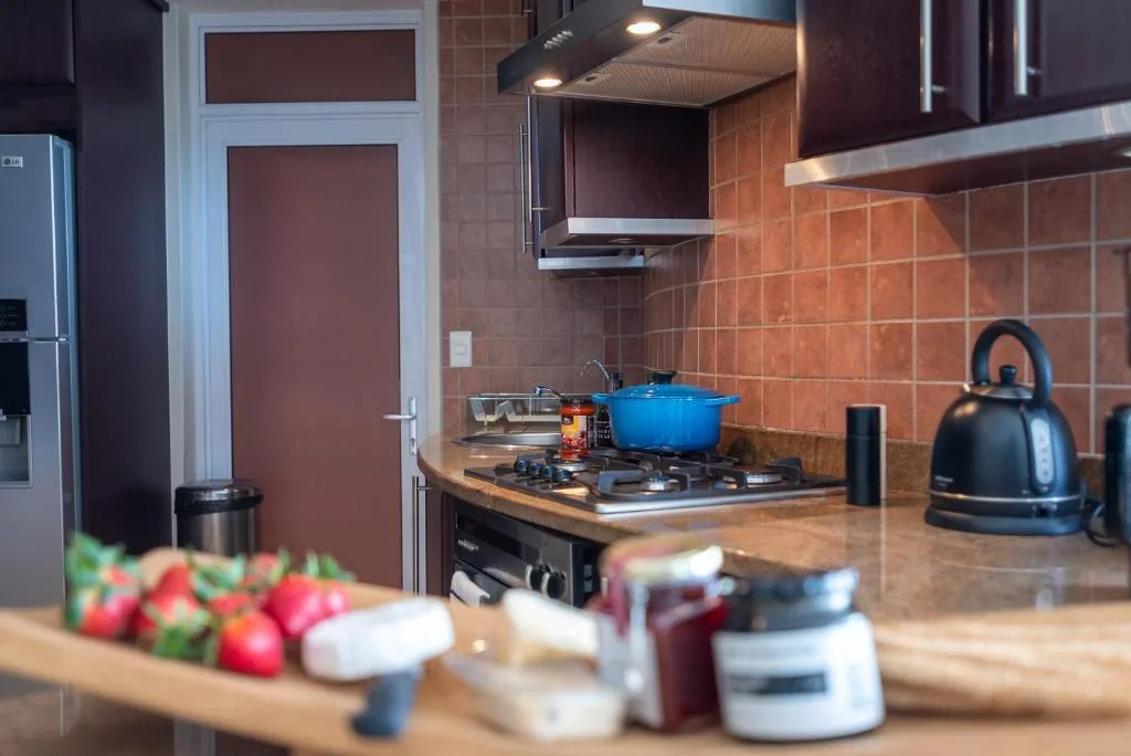 Modern kitchen with gas stove, blue pot, and terracotta tile backsplash