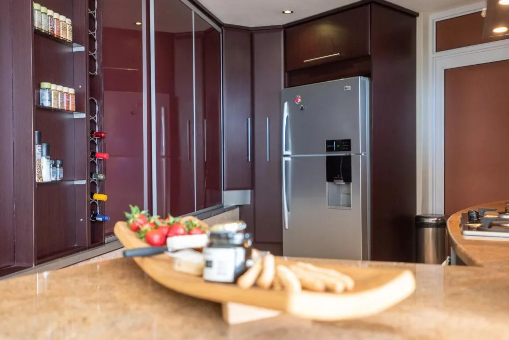 Modern burgundy kitchen with stainless steel refrigerator and marble countertop