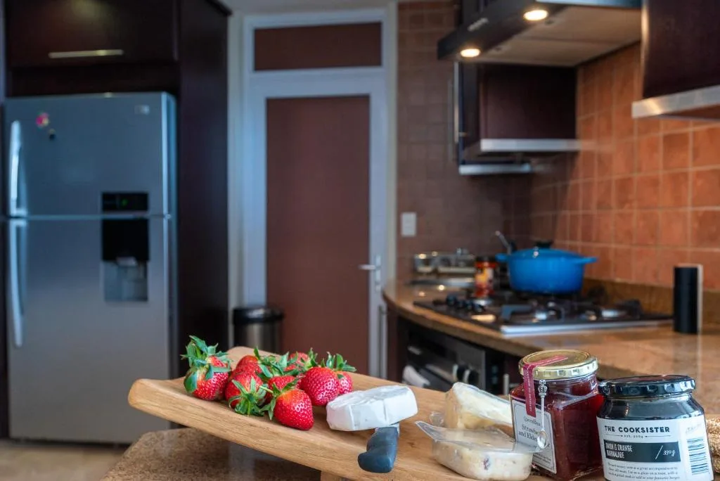 Modern kitchen with stainless steel fridge, gas stove, and fresh strawberries on counter
