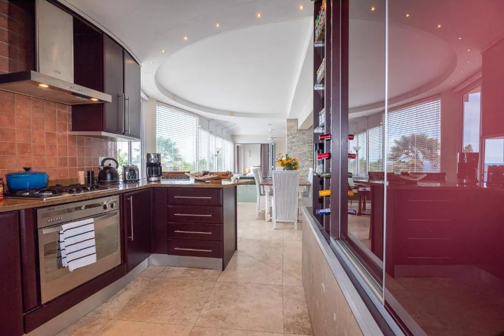 Modern kitchen with burgundy cabinetry, stainless steel appliances, and tiled backsplash